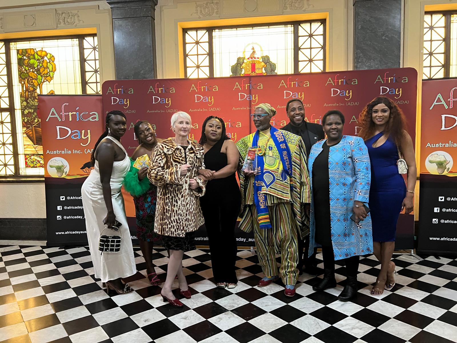 Project Sunrise team and community members at Africa Day Gala backdrop